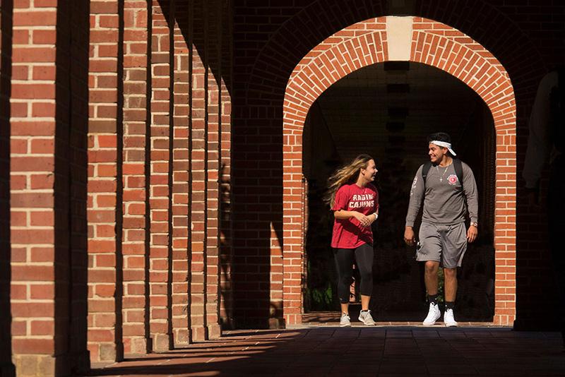 Two University of Louisiana at 69传媒 students walking through the archways on campus
